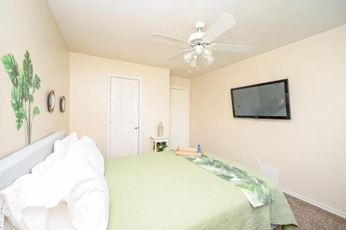 a bedroom with a bed and a flat screen tv at Elegant and Spacious Retreat in Tomball
