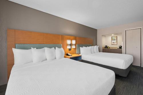 two beds in a hotel room with white pillows at Country Inn & Suites by Radisson, Near The National Sports Center, Coon Rapids, MN in Coon Rapids