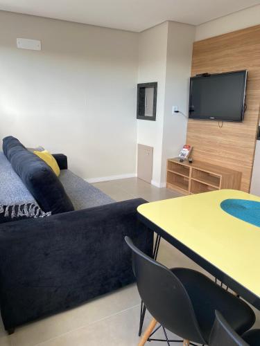 a living room with a couch and a table with chairs at Dallas apartamentos na Via Gastronômica-Estacionamento-Amplos e equipados-Wifi in Bento Gonçalves