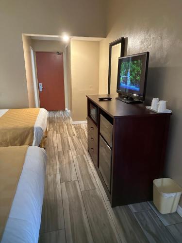 a hotel room with a bed and a flat screen tv at A-1 Budget Motel in Homestead