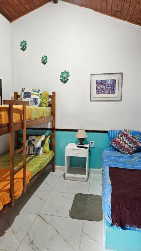 a bedroom with two bunk beds and a table at Casa Vermelha Búzios in Búzios
