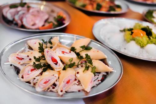 a plate of food on a table with plates of food at Trzy Korony in Głogów Małopolski