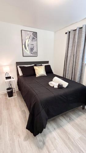 a bedroom with a large bed with black sheets at Studio A- Travel, work and play only minutes away in Birmingham