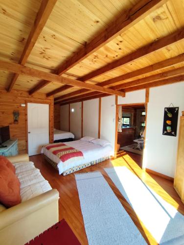 克利翁Cabaña en Quellón的房间里有一张床和一张沙发的卧室