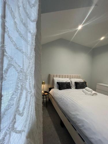 a bedroom with a bed with a white curtain at Modern 2Bed Netflix & Free Parking Telford Gem in Dawley