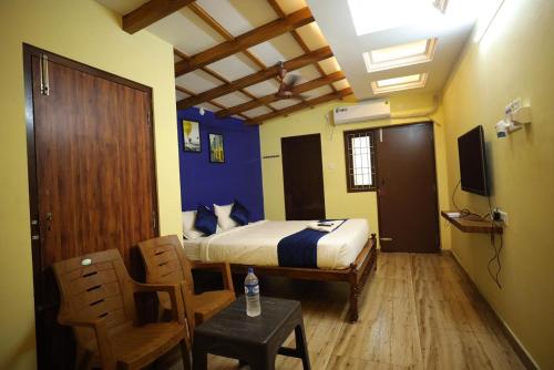 a bedroom with a bed and a table and chairs at JARDIN Pradisiaque in Puducherry