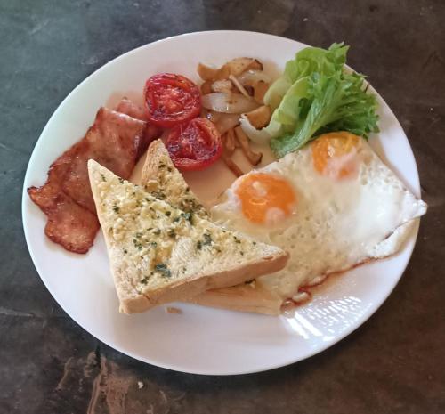 a plate of breakfast food with eggs toast and vegetables at สวนเกษตรรักษ์ไผ่ Bamboo Conservation Farm in Surin