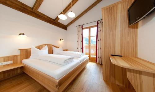 a bedroom with a large bed and a television at Tauernchalets in Grossarl