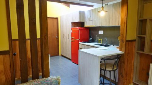 a kitchen with a red refrigerator and a counter at Estero El Claro Hotel y Cabañas in Pucón