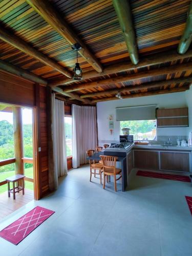 a kitchen with wooden ceilings and a table and chairs at Casa temporada Grecco Vidal in Venda Nova do Imigrante