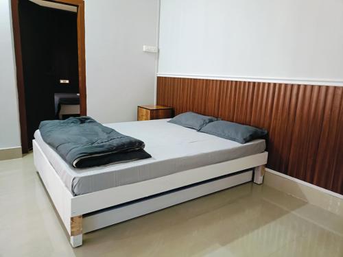 a bedroom with a bed with a wooden headboard at Areca Homestay in Guwahati
