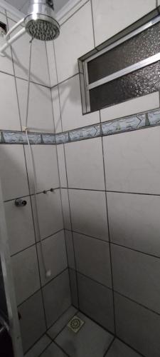 ein Badezimmer mit Dusche und Fenster in der Unterkunft Casa em Tramandaí in Tramandaí