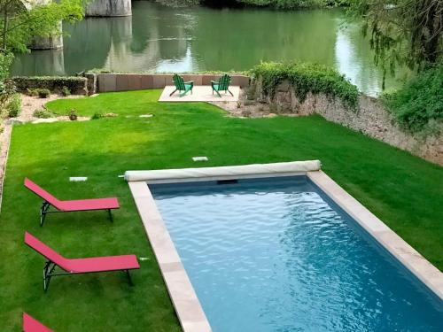 une cour arrière avec une piscine et deux chaises dans l'établissement Maison familiale près du Zoo de la Flèche avec piscine chauffée, jardin et cheminée - FR-1-410-377, à Bazouges-sur-le-Loir