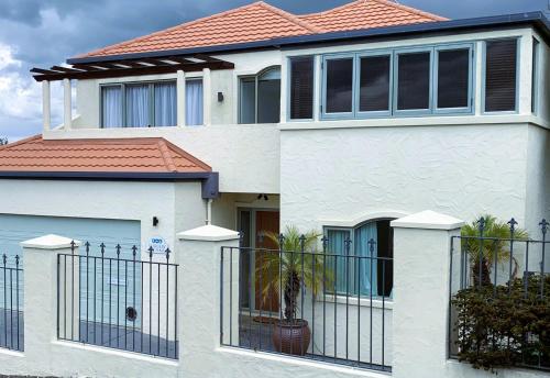 a white house with a fence in front of it at Seaview on Sealy Apartment in Napier