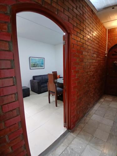 a brick wall with an archway into a living room at Apartamento NUEVO en el centro de Palmira apto 2 in Palmira