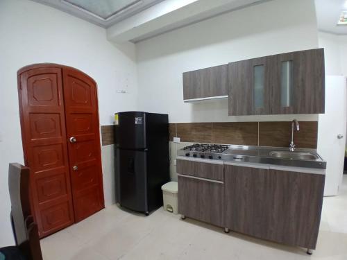a kitchen with a stove and a refrigerator at Apartamento NUEVO en el centro de Palmira apto 2 in Palmira