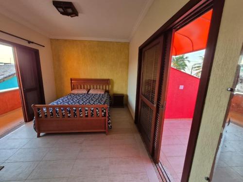 a bedroom with a bed and a sliding glass door at Casa magnífica na praia in Mongaguá