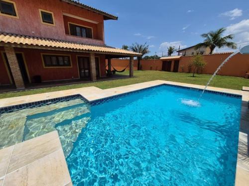 a swimming pool in front of a house at Casa magnífica na praia in Mongaguá