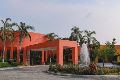 an orange building with a fountain in front of it at Hotel Terranova in Coatzacoalcos