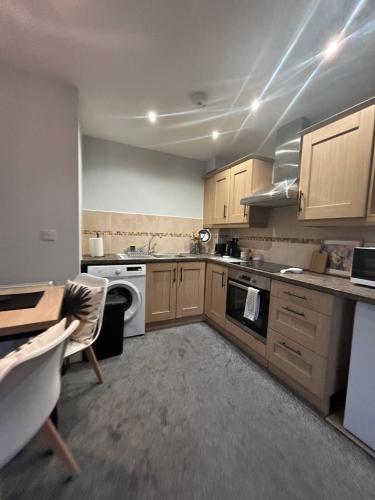 a kitchen with wooden cabinets and a stove top oven at Modern 2Bed Netflix & Free Parking Telford Gem in Dawley