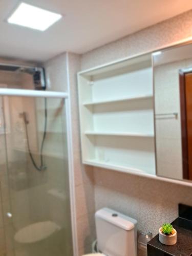 a bathroom with a shower and a toilet and a mirror at Apartamento Beach place Cumbuco 100metros Praia in Caucaia