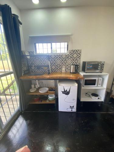 a small kitchen with a counter and a microwave at BarraMar in Barra de Portezuelo