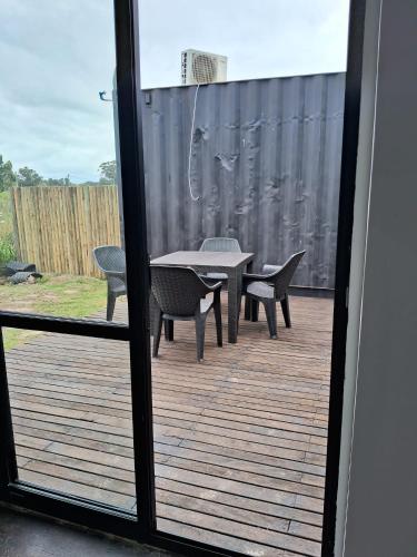 a patio with a table and chairs on a deck at BarraMar in Barra de Portezuelo