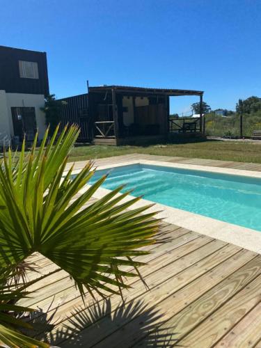 a palm tree in front of a swimming pool at BarraMar in Barra de Portezuelo