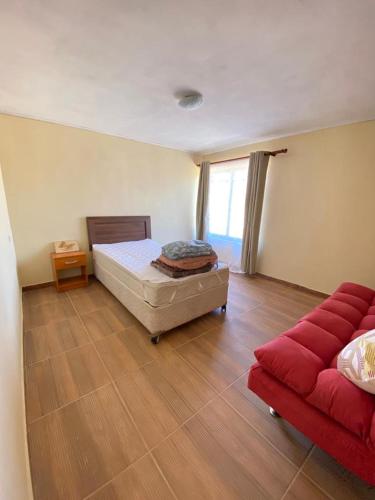 a bedroom with a bed and a red couch at Casa Haciendado de Lolol in Alto de Nerquihue