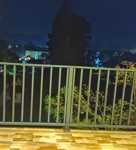 a white railing on a balcony at night at The Blues Chalet in Nuwara Eliya