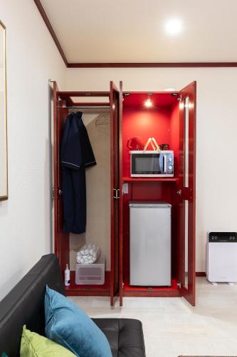 a living room with a red door and a microwave at Hotel Furano Verde in Furano