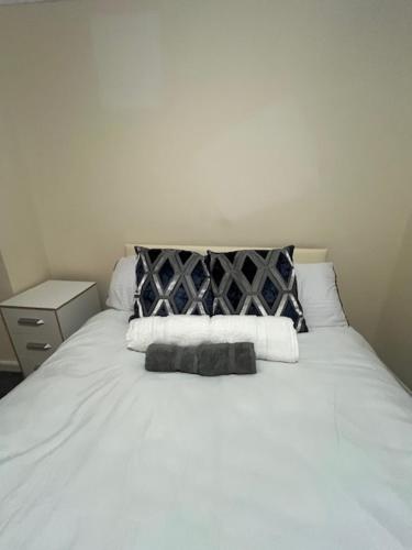 a white bed with two pillows on top of it at Barnfield Rooms in Chelmsford