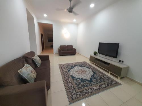 a living room with a couch and a flat screen tv at Homestay As Sofiyya 1 in Sungai Petani