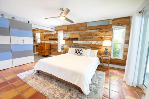 サラソタにあるEnchanted & peaceful Oasis 10 min away from one of the most beautiful beaches in the World Siesta keyの白いベッドと木の壁のある寝室