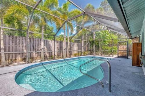 a large swimming pool in a house with a fence at Enchanted & peaceful Oasis 10 min away from one of the most beautiful beaches in the World Siesta key in Sarasota