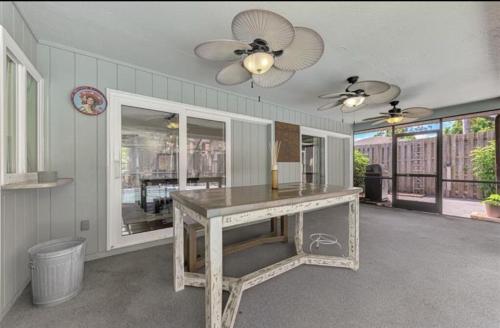 a dining room with a table and a ceiling fan at Enchanted & peaceful Oasis 10 min away from one of the most beautiful beaches in the World Siesta key in Sarasota