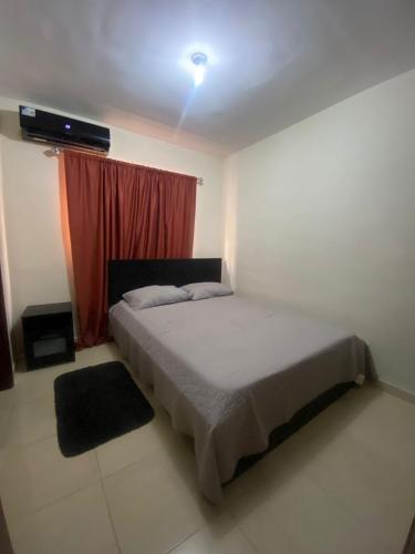 a bedroom with a bed and a red curtain at Como apartamento in La Javilla