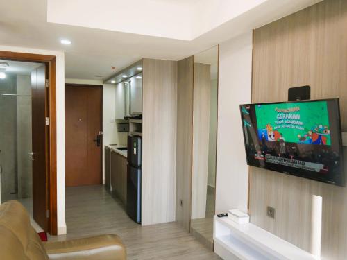 a living room with a flat screen tv on a wall at Meisterstadt Pollux Habibie in Batam Center
