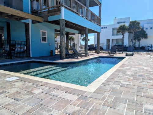 a swimming pool in front of a building at Blue Horizon at Pensacola Beach - Heated Pool, Across beach access, Beach gear, Dogs OK! in Pensacola Beach