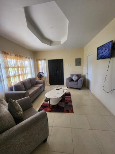 a living room with couches and a coffee table at AG3K Oasis in Buccoo