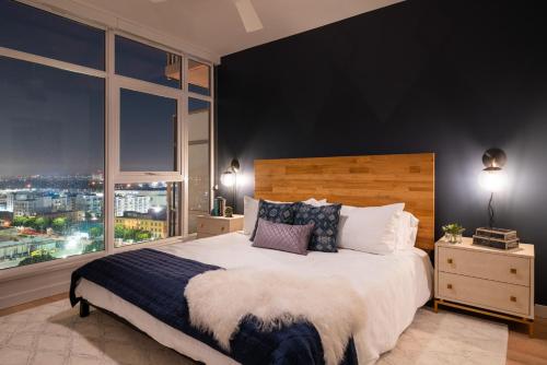 a bedroom with a large bed with a large window at Sky-Rise Apartments in Los Angeles