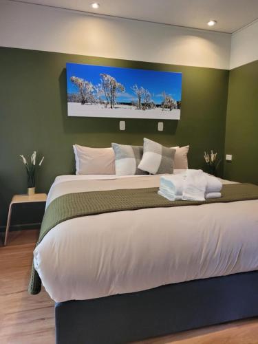 a bedroom with a large bed with a tv on the wall at The Bright Motor Inn in Bright