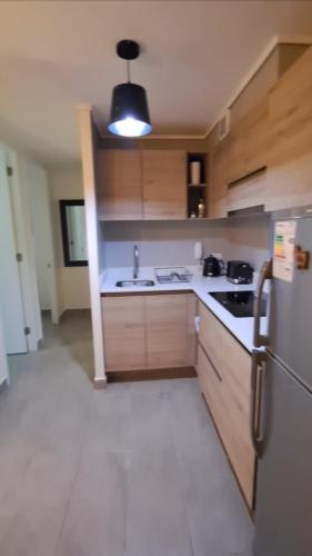 a kitchen with wooden cabinets and a white refrigerator at Montenegro 2 dormitorios in Temuco