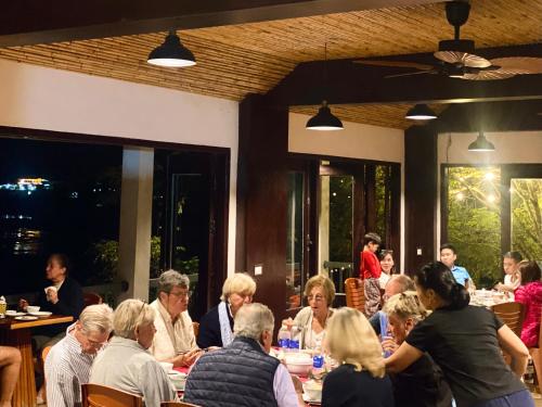 a group of people sitting at tables in a restaurant at Ba Be Lakeside Bungalow in Ba Be
