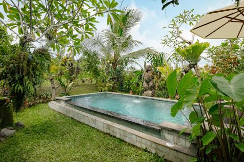 a swimming pool in the yard of a garden at Moringa Ubud Villa in Ubud