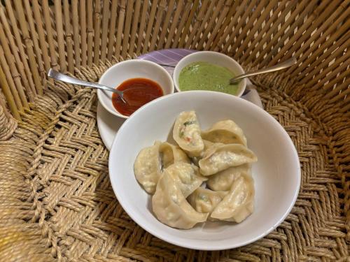 einen Teller mit Knödeln und zwei Schüsseln Soße in der Unterkunft Eva Cabins in Dalhousie