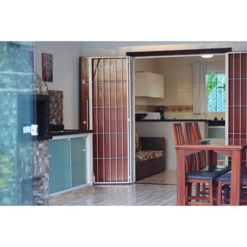 una cocina con una puerta que da a una cocina con mesa en Reserva Itapoá SC - Casa Jacuzzi, en Itapoa