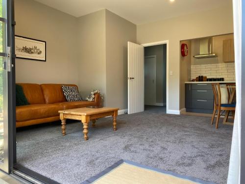 a living room with a couch and a table at Secluded coastal comfort in Dunedin
