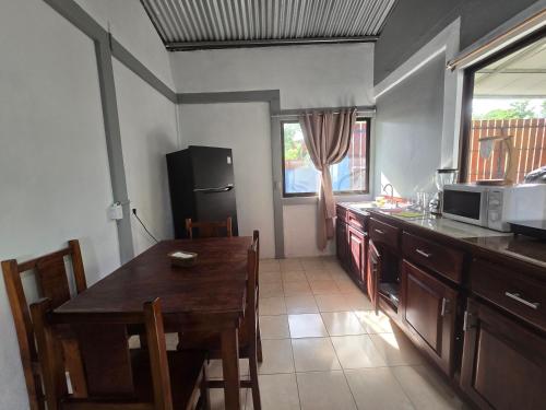 a kitchen with a wooden table and a microwave at Casita el Jardin in Nuevo Arenal
