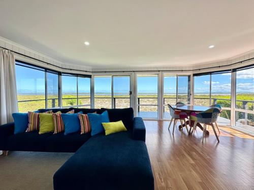 a living room with a blue couch and a table at Water Front in Saint Margaret Island